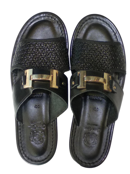 Pair of black sandals with gold buckles on a white background